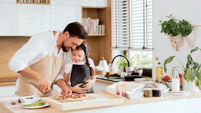Father and daughter meal prepping in a kitchen.