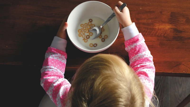 Kid eating bowl of cheerios.