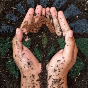 Hands scooping soil with Organic Trade Association logo.