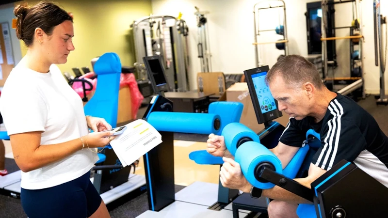 Older man working out with a trainer.