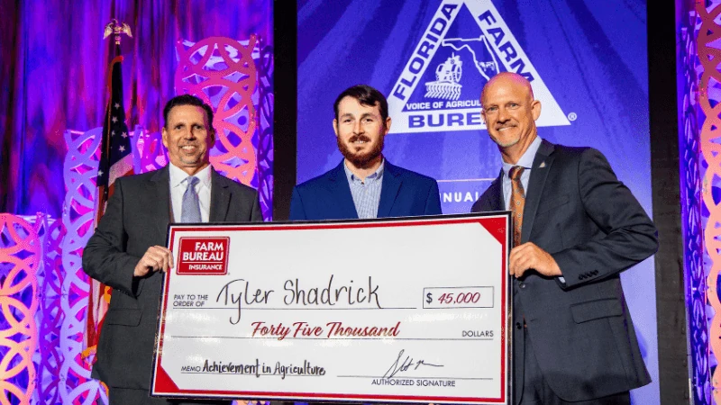 Three men holding a prize check.