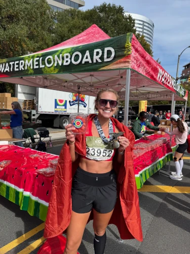 Female Marathon runner pointing to her watermelon.