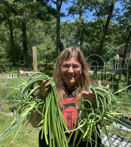 Woman holding garlic harvest.