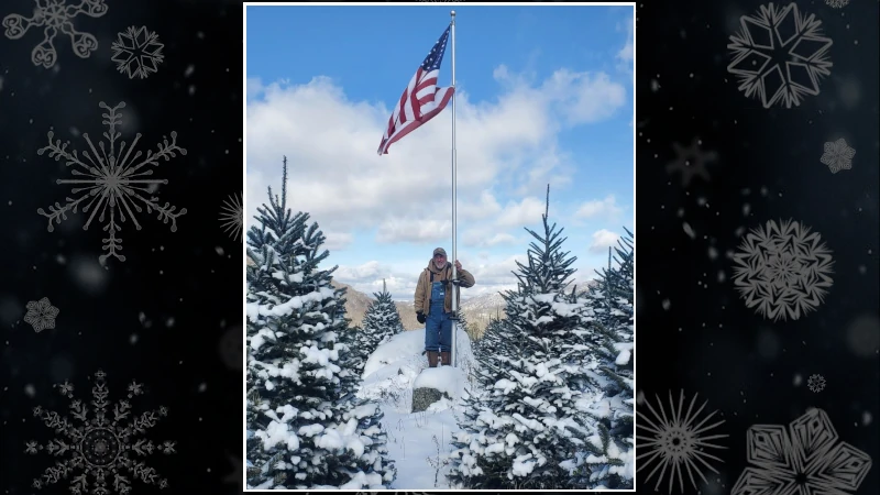 Man on snow top mountain with American Flag.