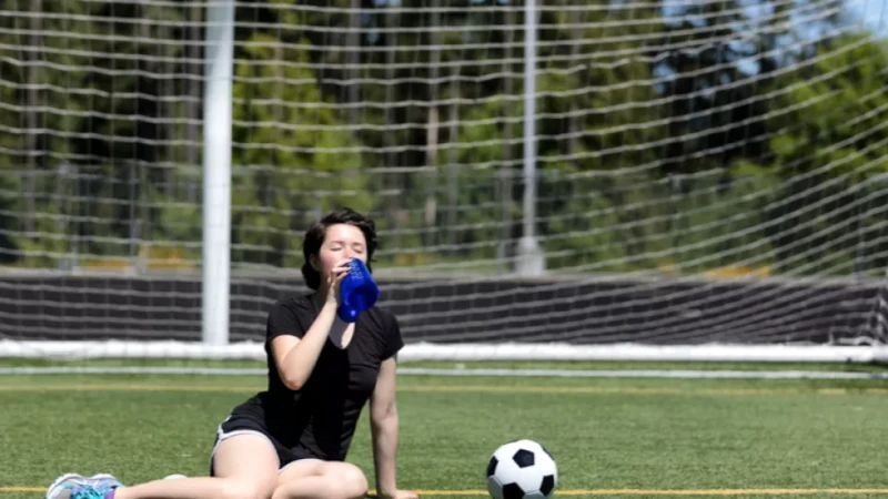 Student athlete drinking water.