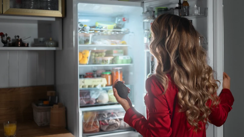 Woman looking in a refridgerator.