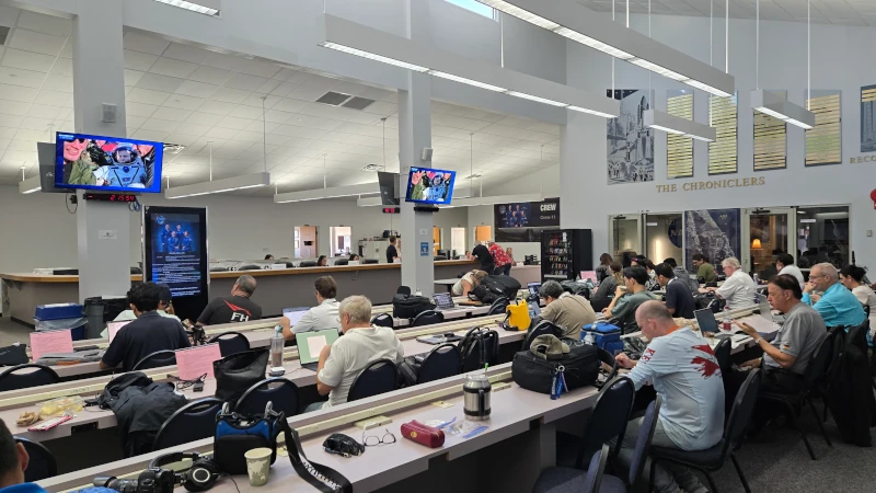 People at desks in media room. 