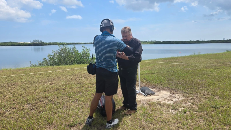 Crew member situating microphone on host.