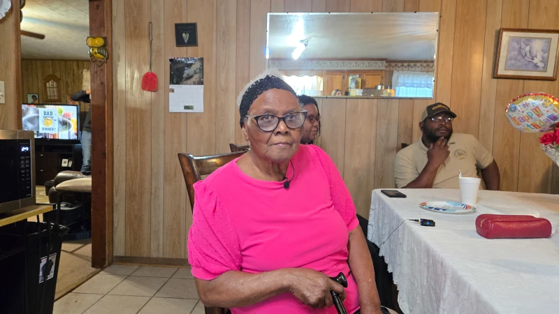 Woman sitting at table in her kitchen.