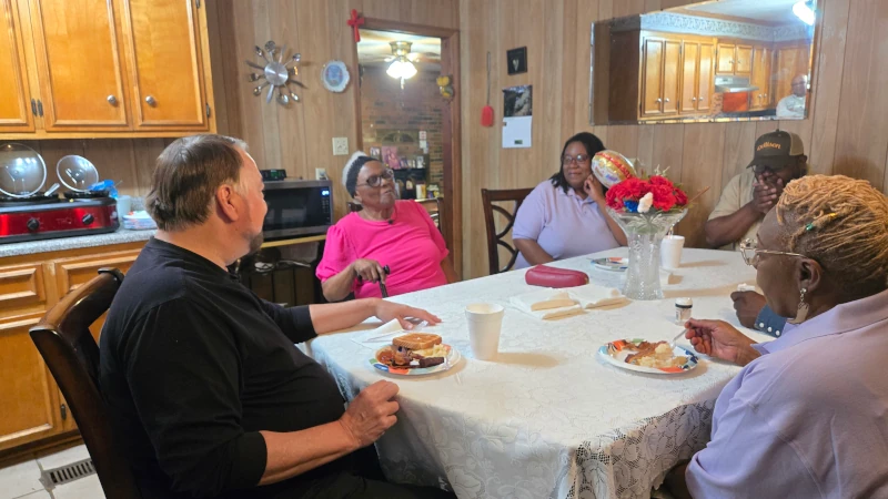 Group of people sitting at breakfast table.