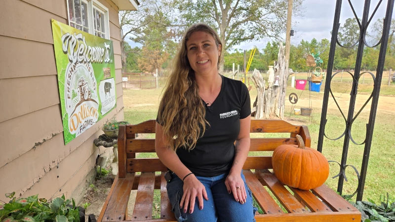 Woman posing for a picture on a porch.