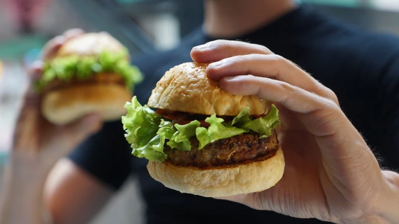 Burger in hand.