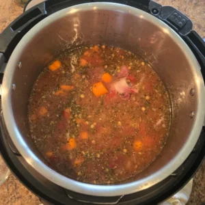Pot of lentil soup with ingredients.