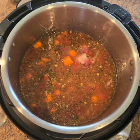 Pot of lentil soup with ingredients.