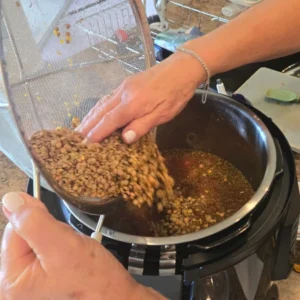 Lentils being added to soup.