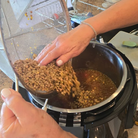 Lentils being added to soup.