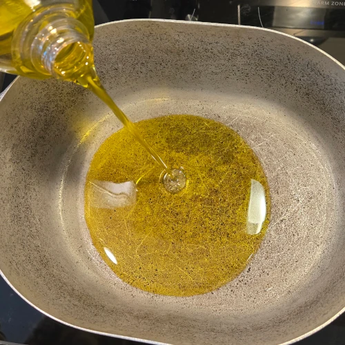 Olive oil being poured into a pot.